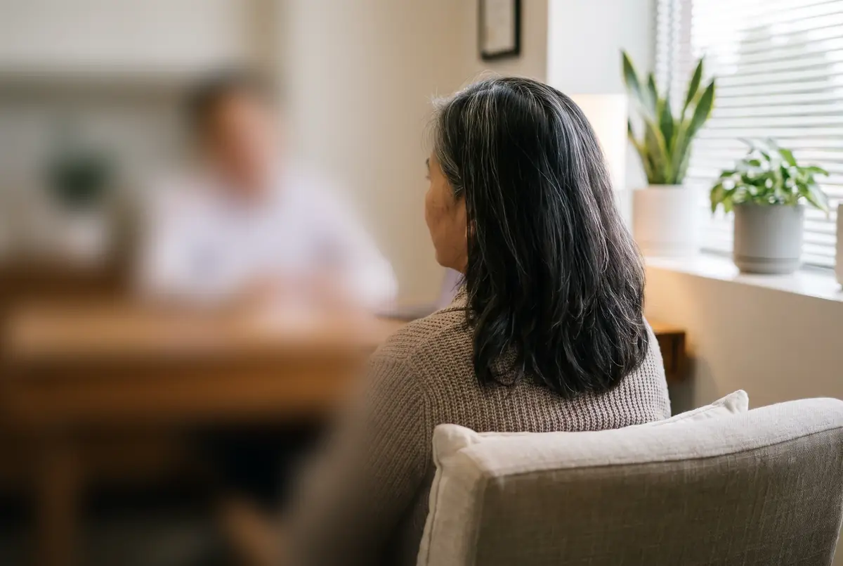 Illustrative image: a woman talking with a doctor in a calm clinic room
